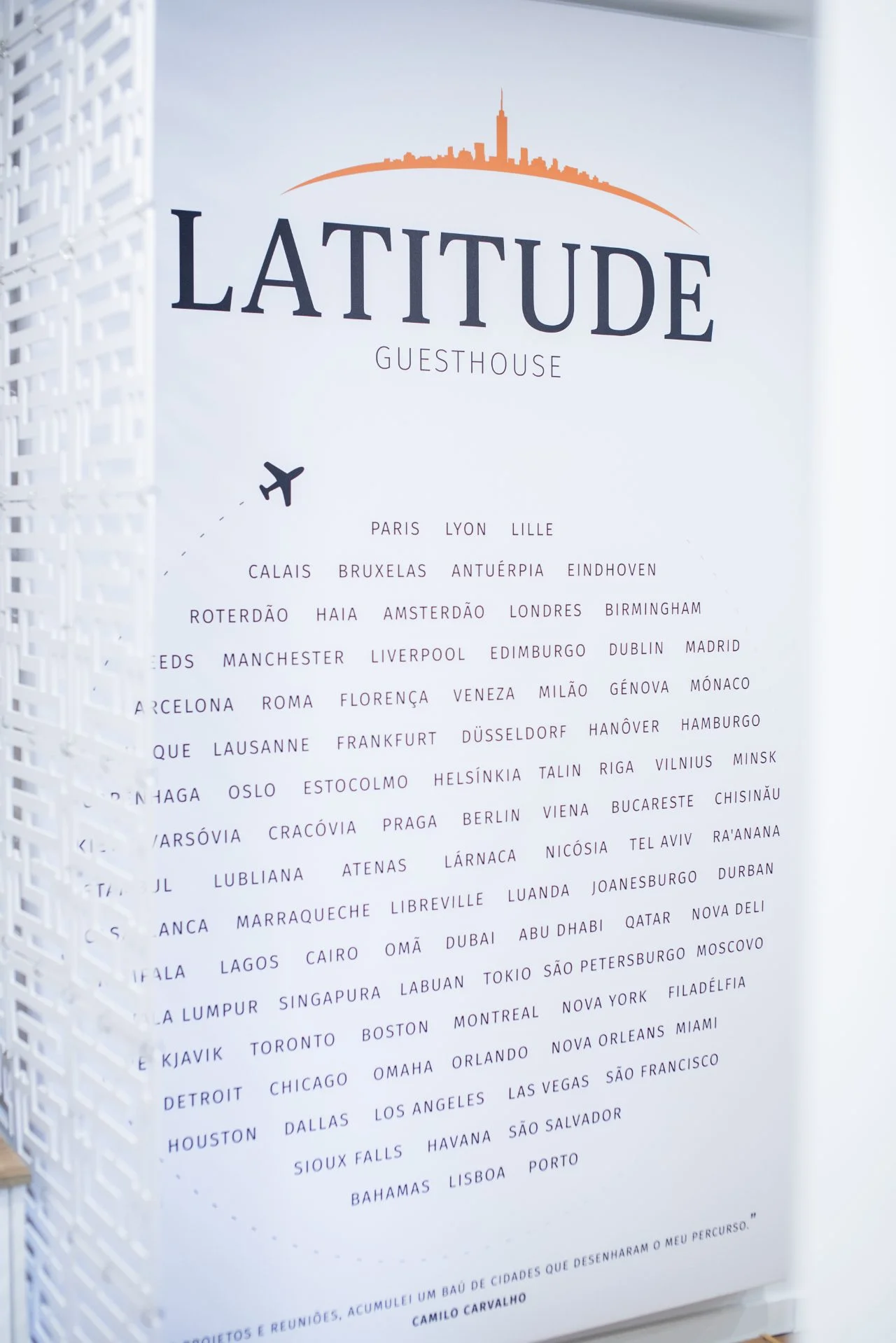 The wall of city names, with the line of a plane connecting them