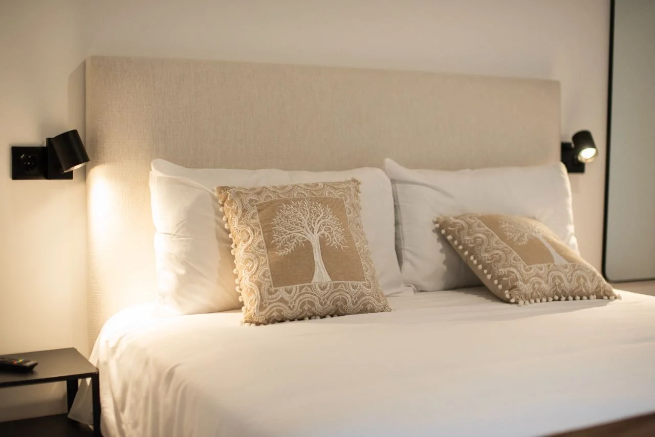 The Dubai room, light headboard, tree-of-life cushions in golden tones and the Dubai skyline with the Burj Khalifa