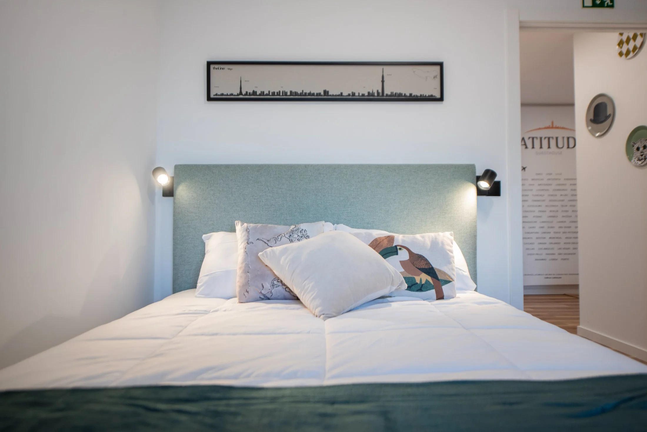 A bright, light-filled room at Latitude, with a city skyline framed above the bed