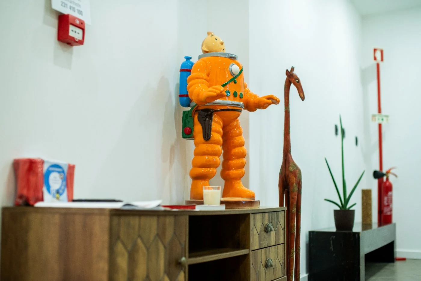An astronaut figurine and travel objects on a sideboard at Latitude